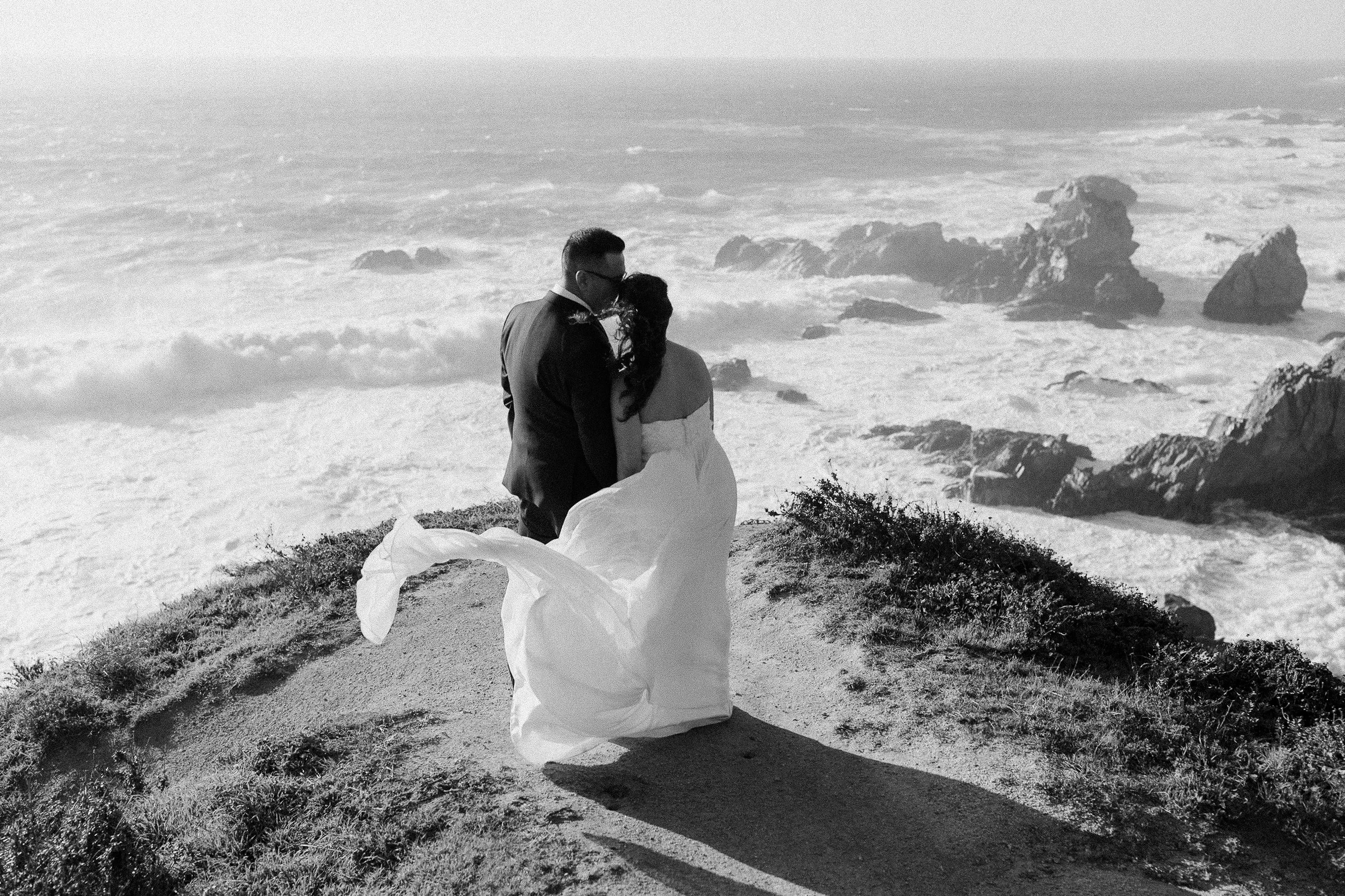 bride and groom on rocks in big sur