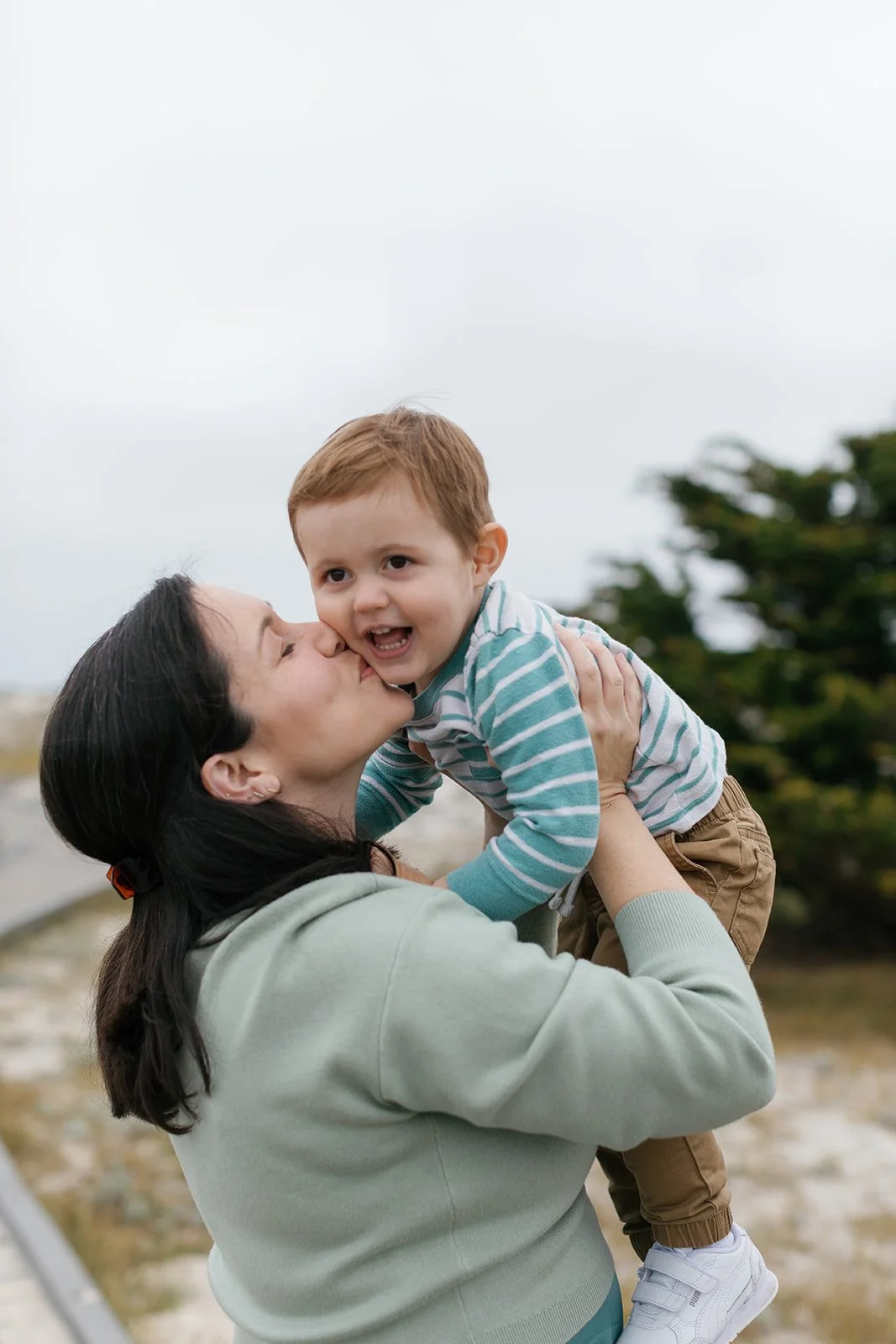 pregant mother kissing son in pacific grove california