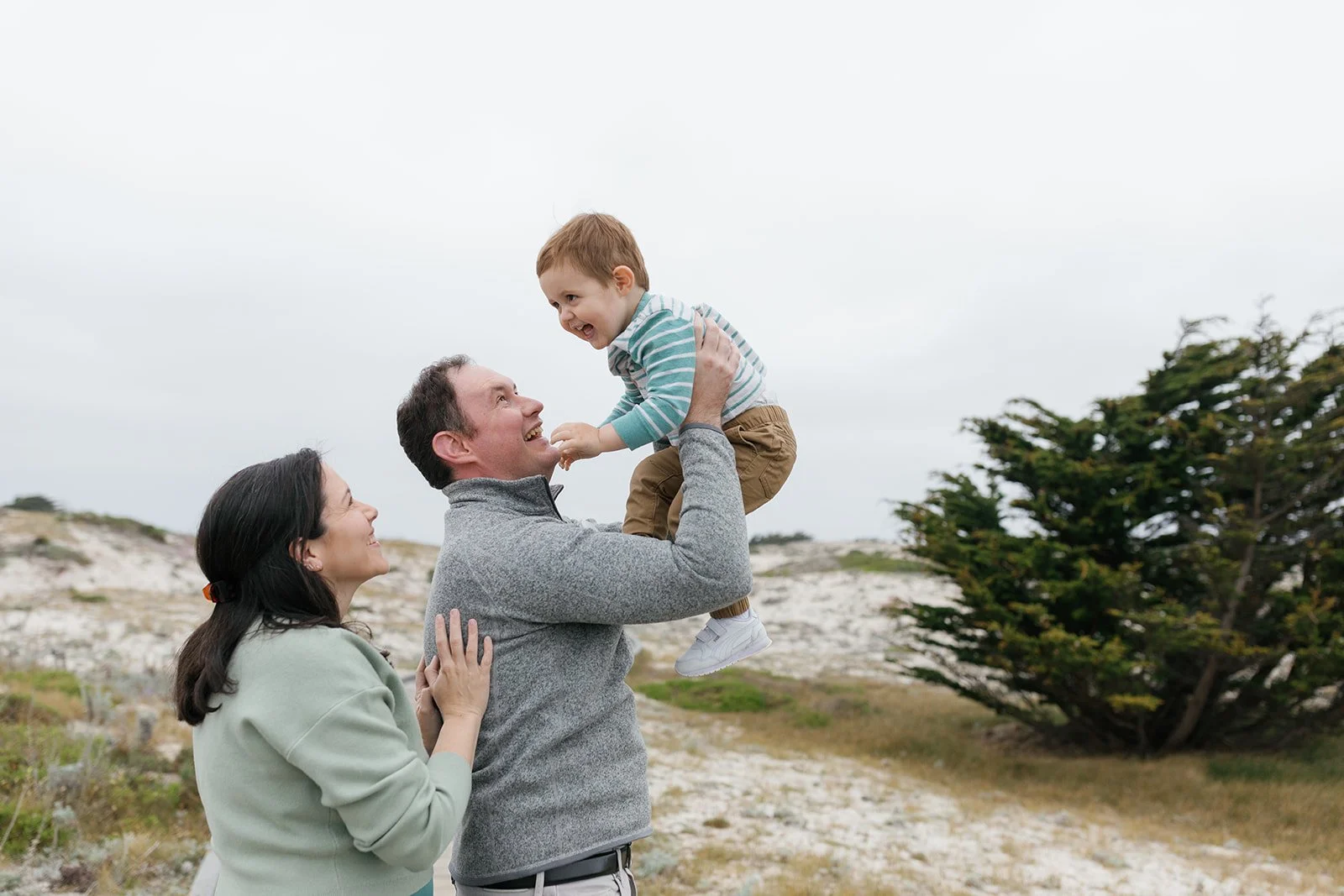 father holding up son pacific grove photos