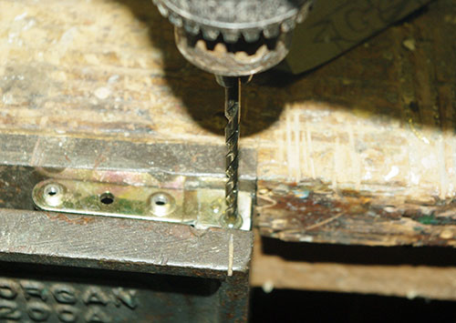Step 2: Drilling the old rivets out of the broken hinge.
