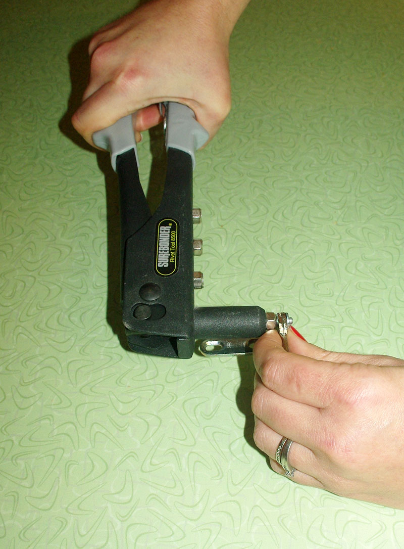 Step 7: Squeeze the handles of the riveter a few times until the tail of the rivet breaks off and the two parts of the hinge are connected.