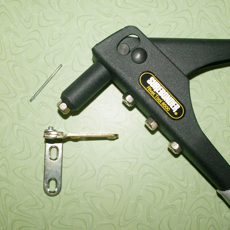 The repaired hinge with its new rivet.