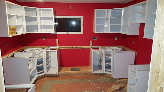 Cabinets during installation, on custom wooden plinth.
