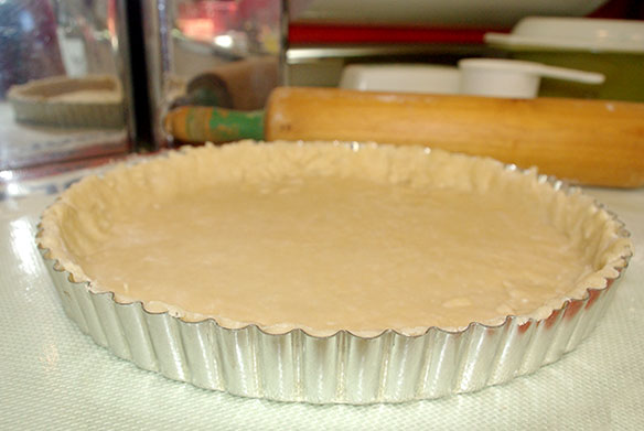 The tart pan lined with dough 