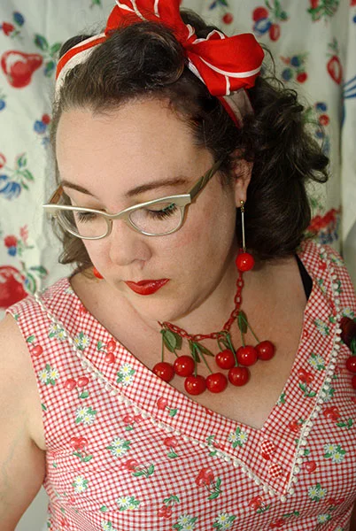 The bodice with mini pom-pom trim and plastic gingham buttons.