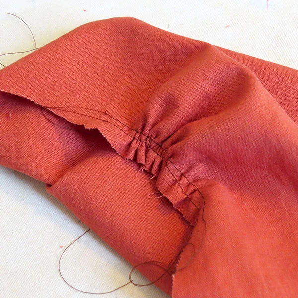 The rust-colored linen fabric, with some of the gathers for the upper bodice.