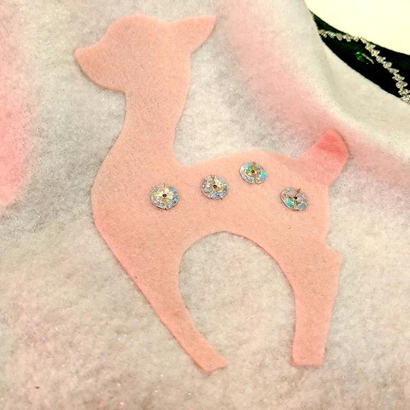 A close-up of one of the deer appliqués with sequin spots