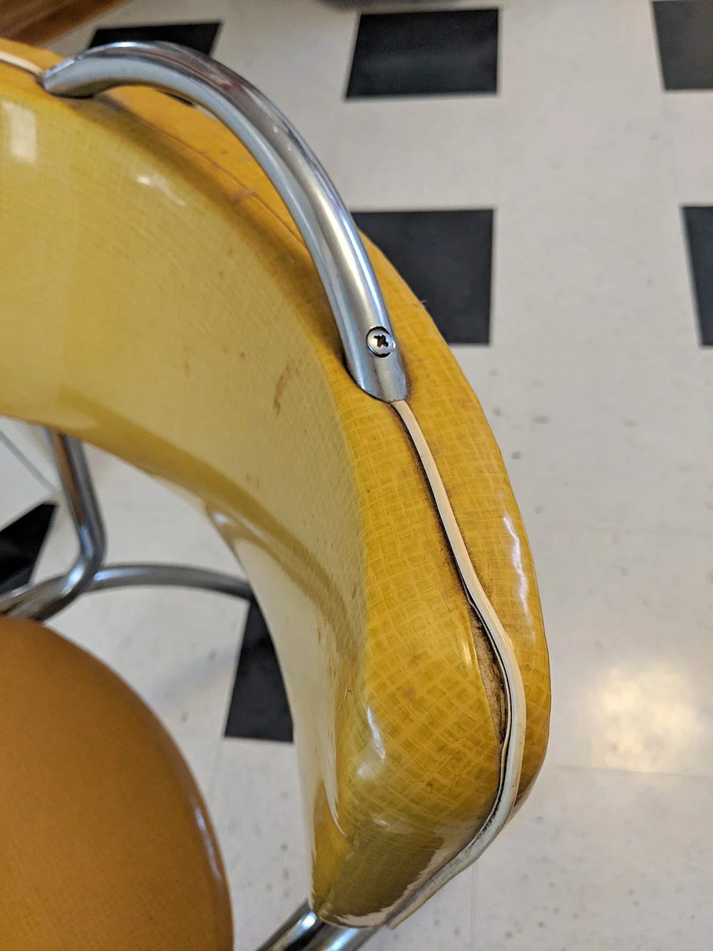 Some of the splitting on the edge of the chair.