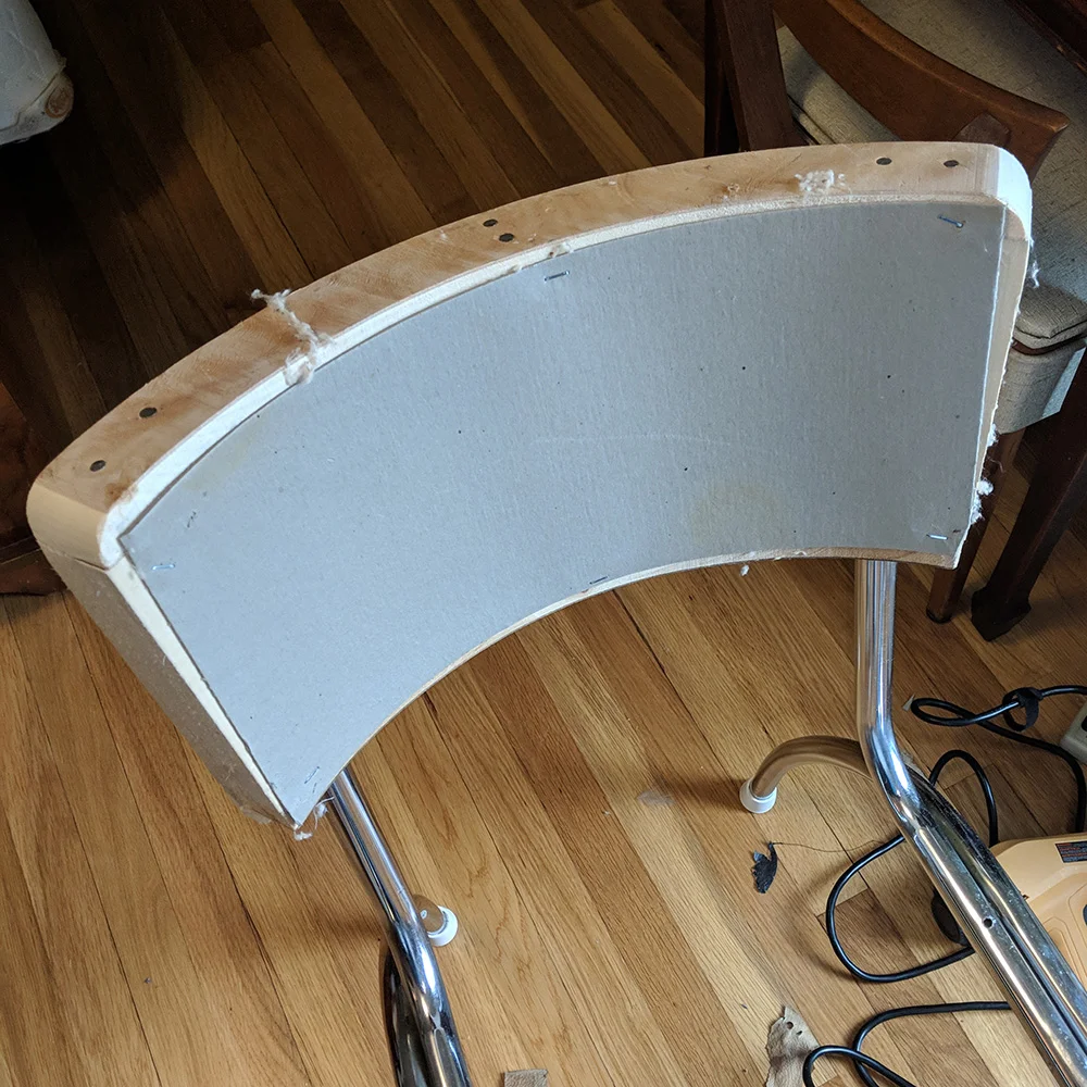 The chair back with cardboard covers. I initially removed this to see how it was put together, but this should only be removed if it is in bad shape and needs to be replaced.