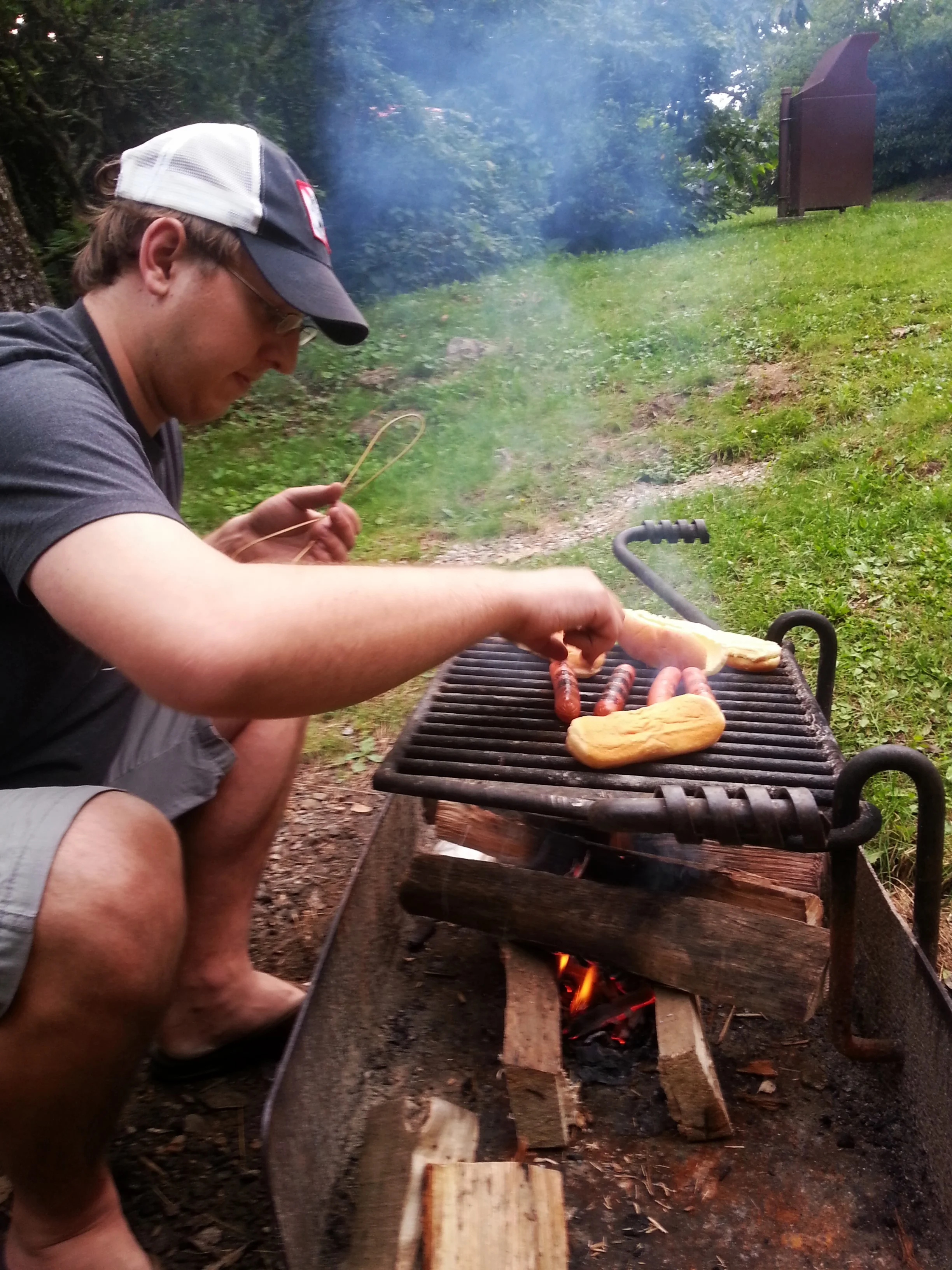 Despite the drizzling rain McCrae got just enough fire going to toast some hotdogs and buns.