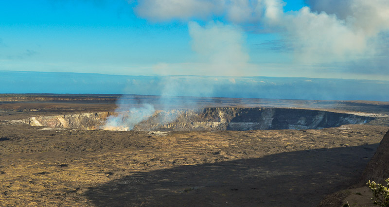 Halema'uma'u Crater, smoking and shedding vog (aka air pollution composed of sulfur dioxide and other gases and particles that react with oxygen and moisture in the presence of sunlight.) Vog is a portmanteau of "volcanic," "smog" and "fog" (and for the record my blog editor desperately keeps trying to autocorrect it to "fog").
