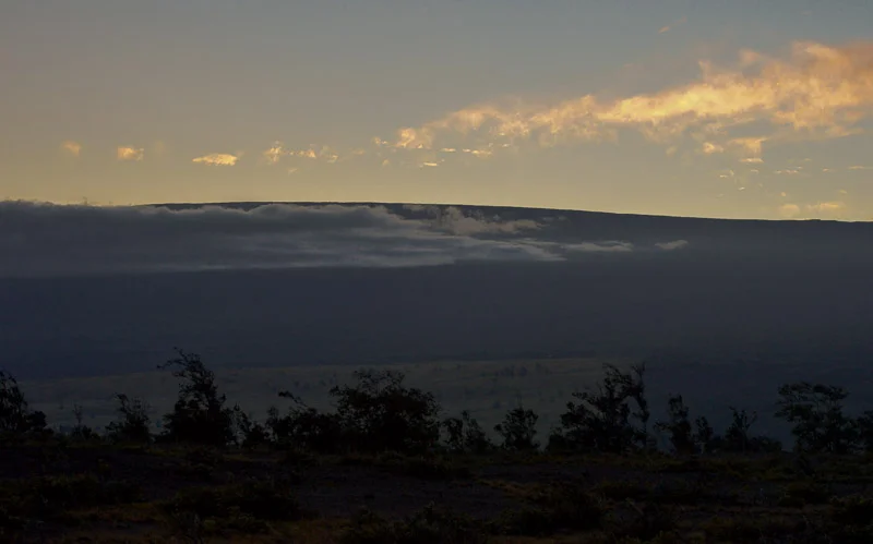 Mauna Loa. It may not look like much except for a slight rise in the horizon against a sunset, but that's only because the mountain is SO BIG. That whole thing is mountain, and it just keeps going.