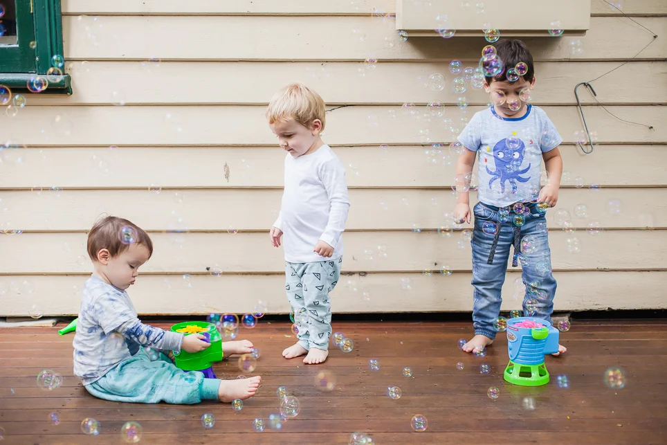 The boys playing together with the bubbles. 