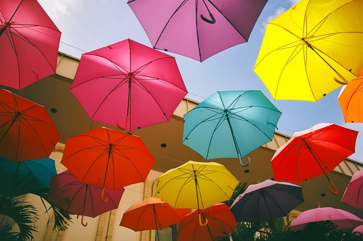 Colorful umbrellas suspended in the air against a blue sky, creating a vibrant canopy.