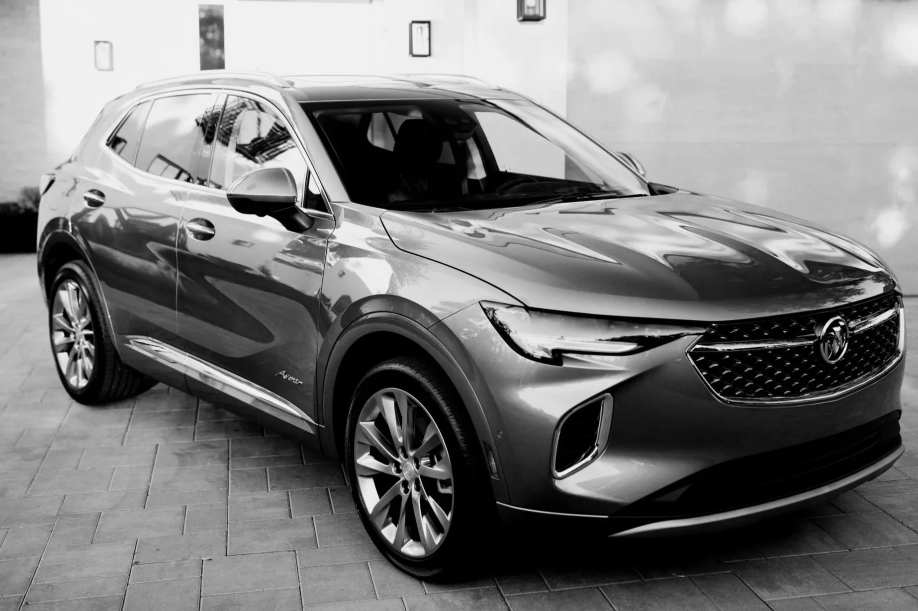 A sleek, modern SUV parked inside a garage with a smooth concrete floor and a large garage door. The vehicle has a shiny exterior and stylish design.