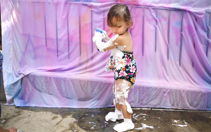  Audrey Hernandez, 2, plays with washable paint in a spray bottle while covered in shaving cream outside the DeKalb Public Library during the Silly Summer Fun event on Wednesday, Aug. 3, 2011. 