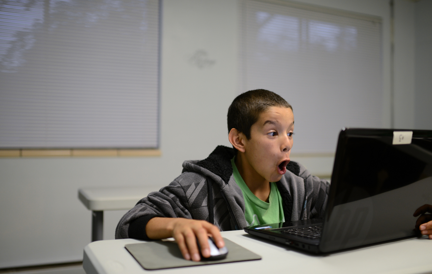 Tony Rivera reacts to a video about ghosts on YouTube while using a laptop in the training room at Freedom House, where he lives, in Green Bay, Wis. on Monday, Sept. 22, 2014. 