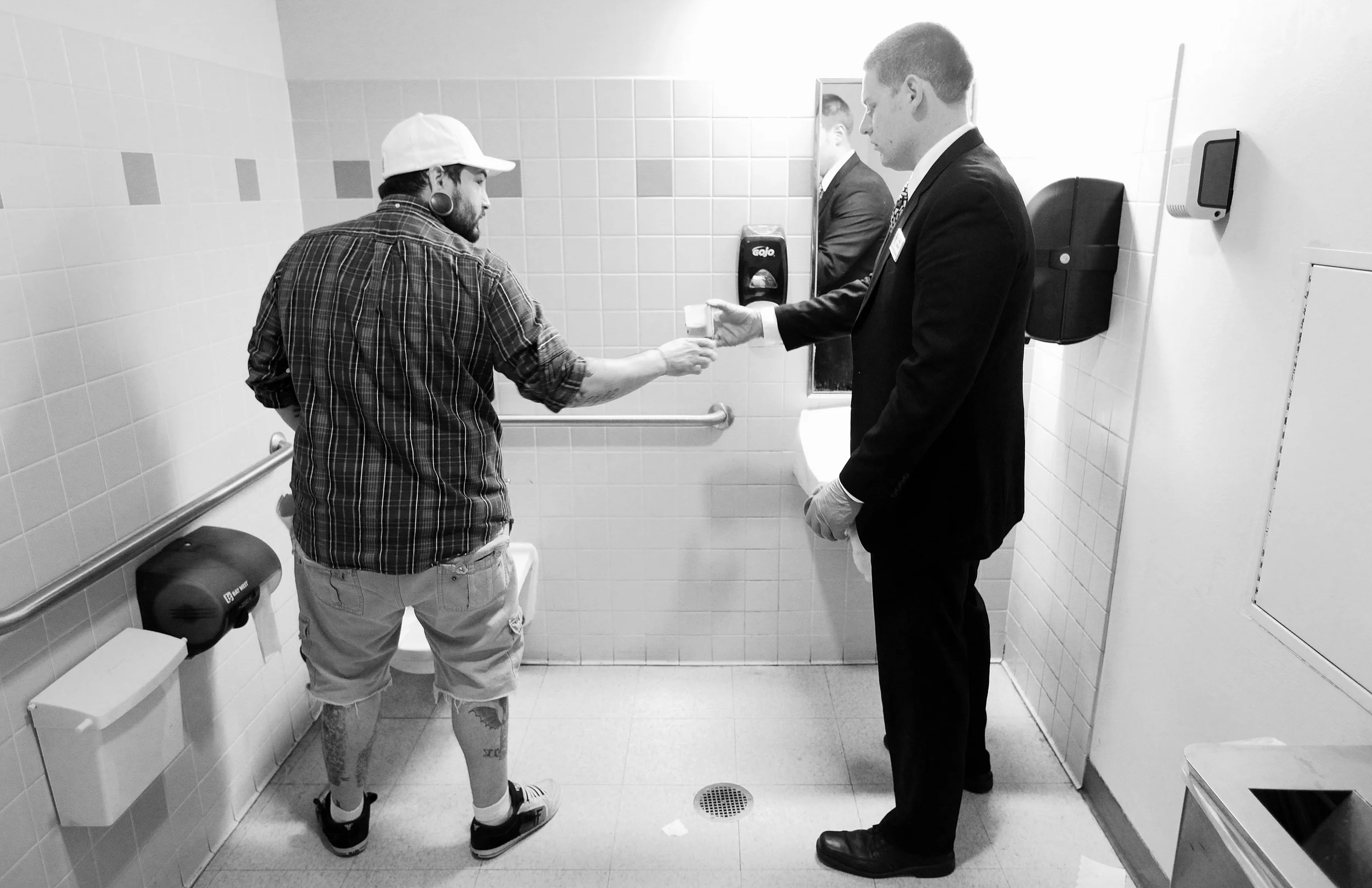   Drug Court Probation Officer Mike Douglas accepts a urine sample from Matt Jordan in a bathroom at the DeKalb County Courthouse on Friday, March 16, 2012 after being in drug court. Jordan also has to call in every day before 8:30 a.m. throughout th