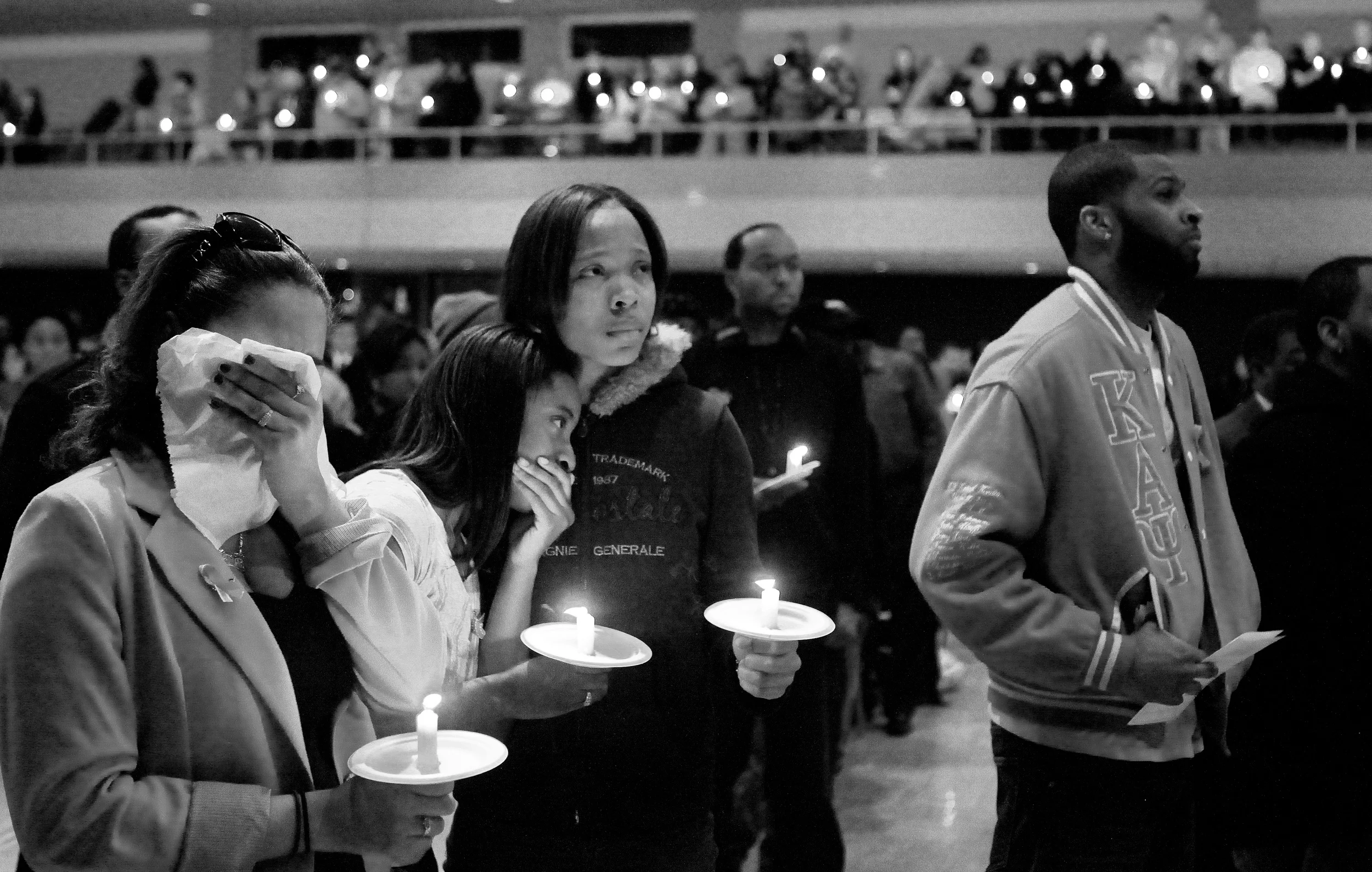 Savannah White leans on Lekeshia Parker (center) as the two tear up Tuesday, Nov. 29, 2011, while watching a slideshow remembering their friend Steven Agee II during a candlelight vigil in the Duke Ellington Ballroom in the Holmes Student Center at Northern Illinois University in DeKalb, Ill.