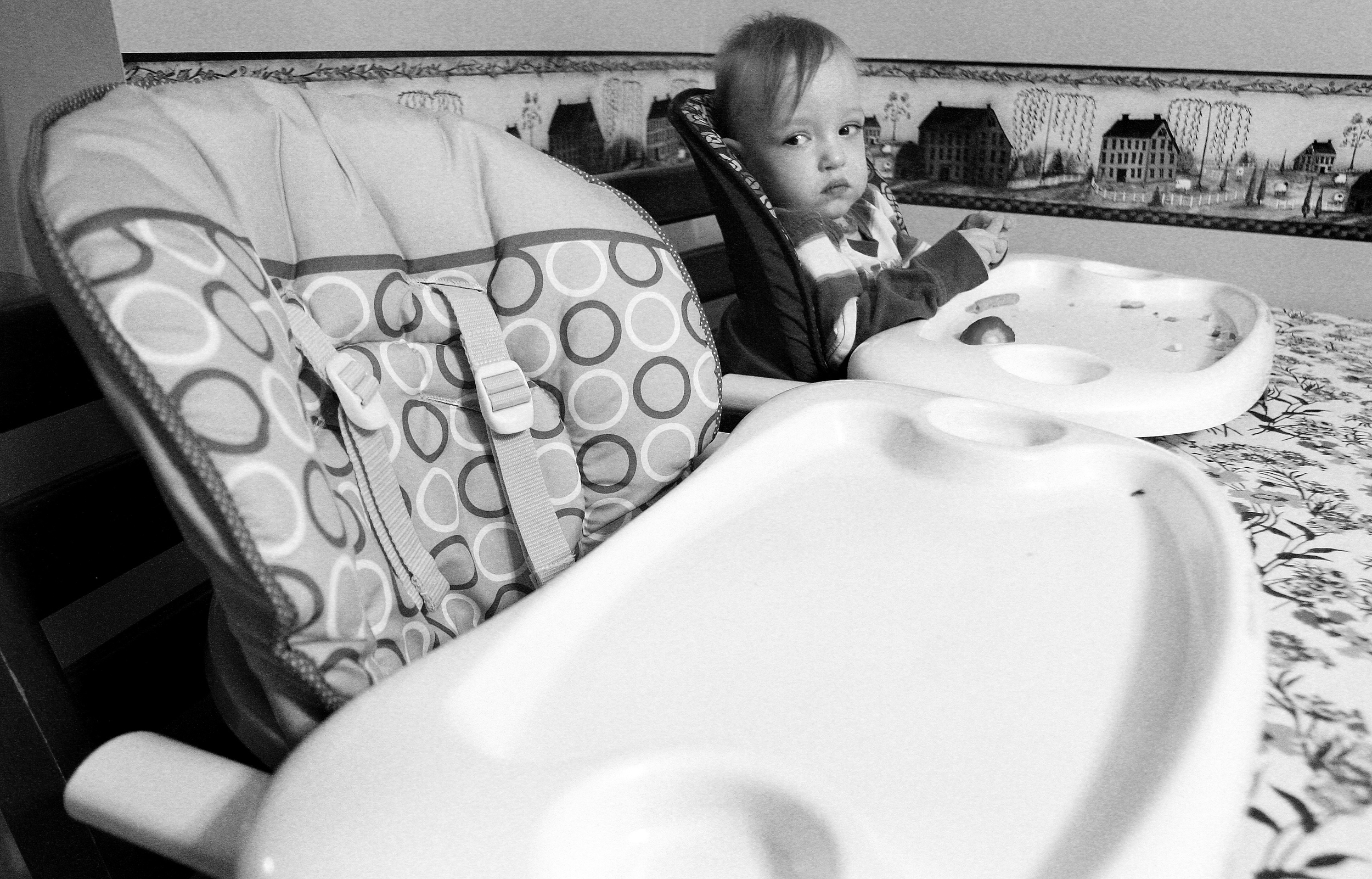   Eighteen-month-old Finn Davis looks to the empty high chair of his identical twin Evan during dinner at the Davis home in Sycamore, Ill. on Tuesday, Feb. 15, 2011. Evan was born with Hypoplastic Left Heart Syndrome and is currently in a hospital ne
