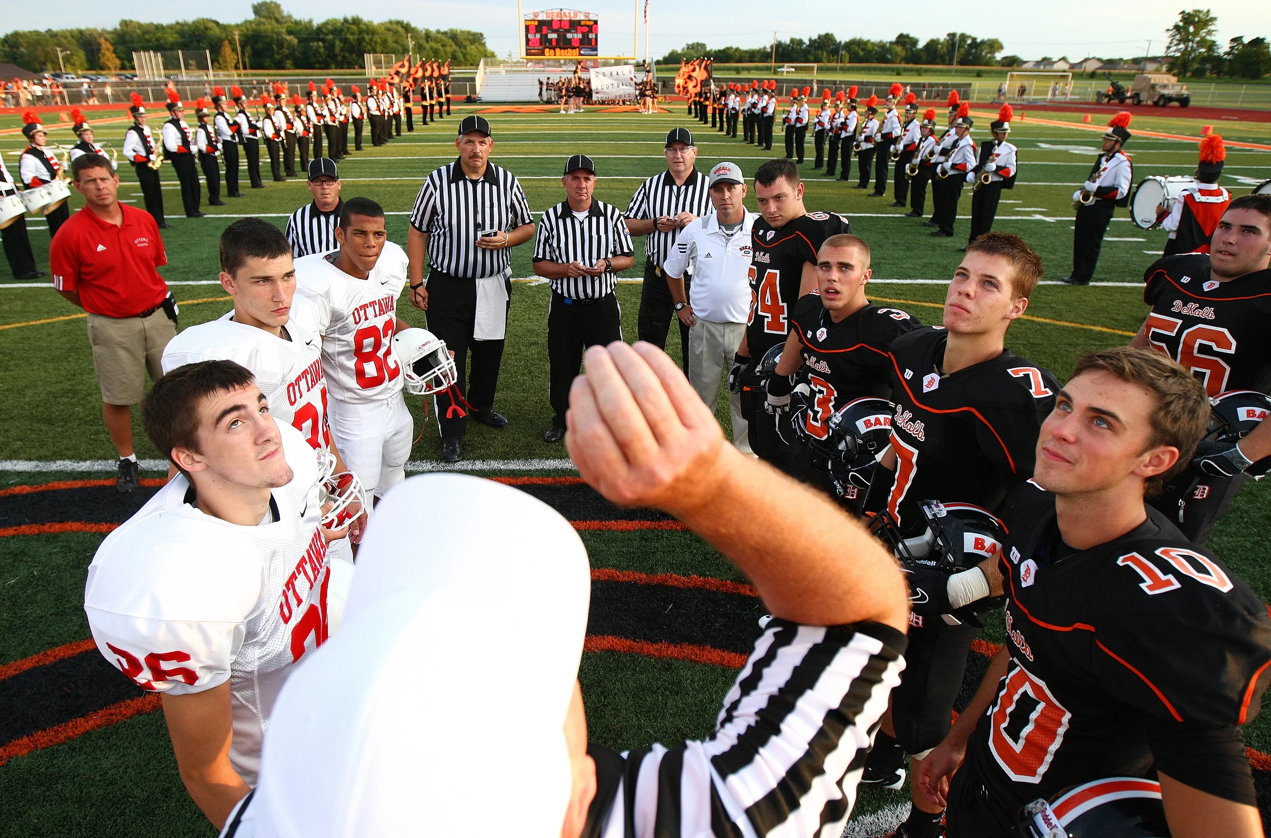Team captains for Ottawa and DeKalb watch the coin flip for the inaugural game at DeKalb's new high school on Friday, Aug. 26, 2011.