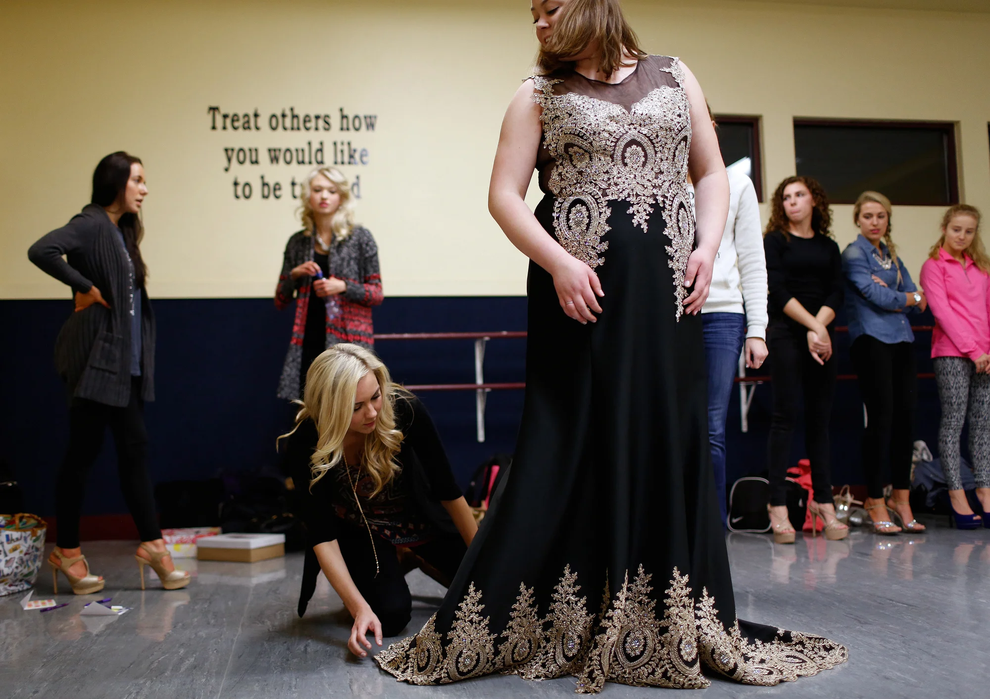  Miss Green Bay Area 2015 Jennie Collins plays a supportive role as she helps the 2016 contestants before the pageant. Here, she helps adjust the evening gown of Miss Green Bay Area 2016 contestant Hannah Lewis as she practices her walk during a dres