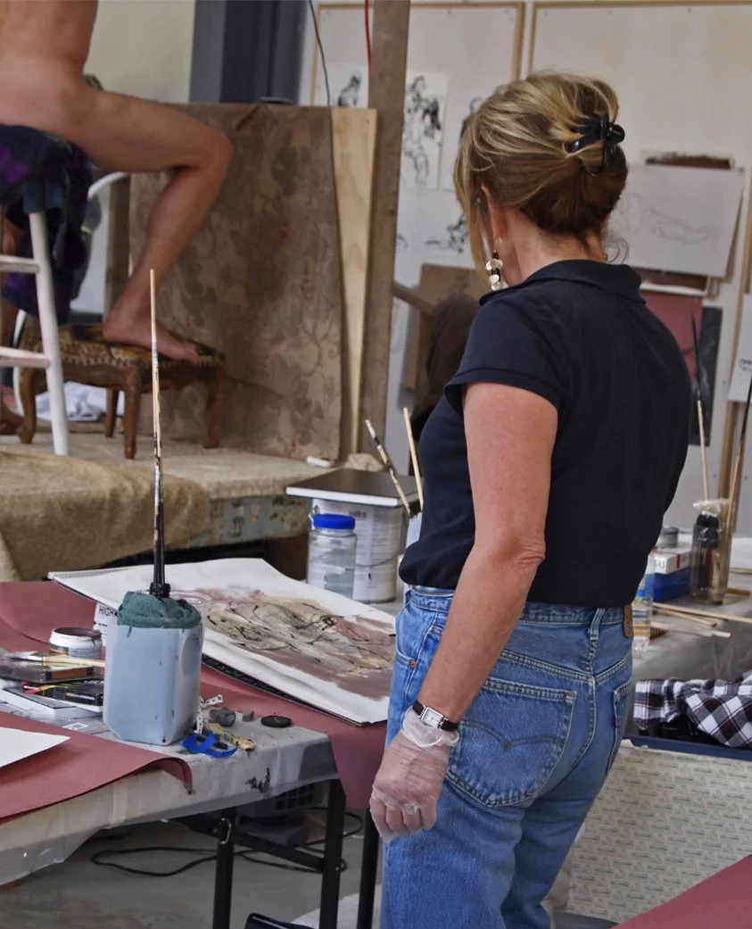 Karen Krahl painting with a long broken dowel and black ink.
