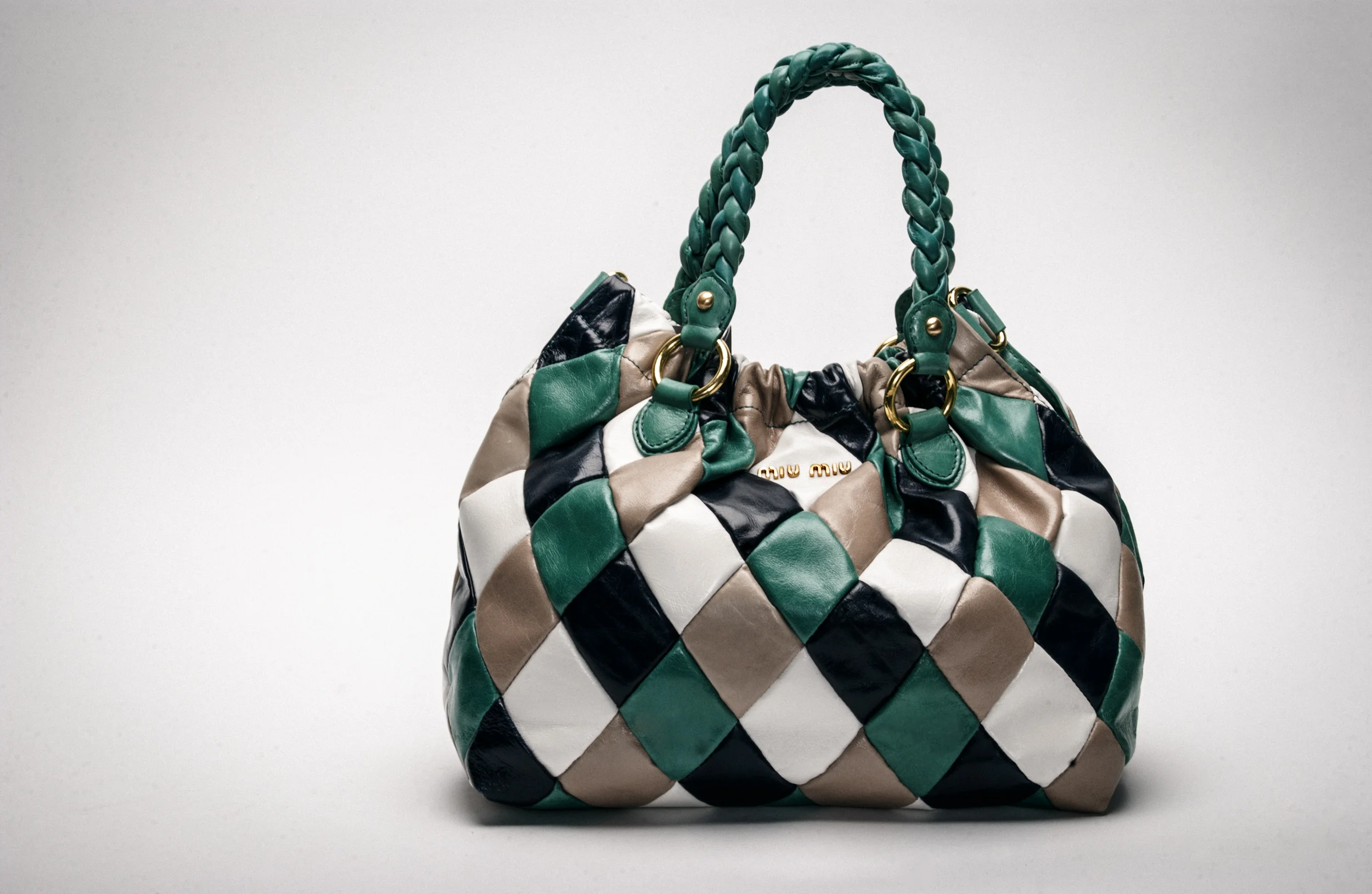 Miu Miu handbag with diamond quilt pattern in green, white, beige, and black.
