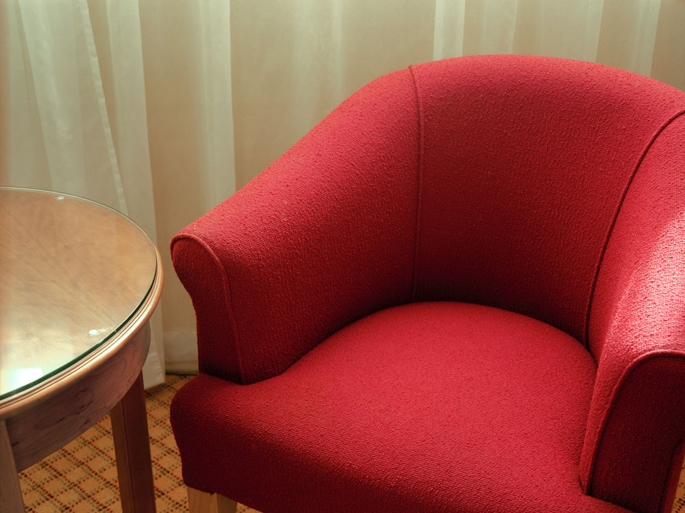 Untitled from the series 310 giclee print 40x50 inches Whilst the hotel is part of a respectable and comfortable chain, this close scrutiny of the surface of things, revealed small imperfections, such as scratches and stains on furniture and hairs snagged in the upholstery of chairs, then its faux mahogany surfaces, shinny brass lamps, and soft furnishings, were in stark contrast to the areas of the hotel that only the staff see, which was bare and dismal. Through understanding this surface of things to be a veneer, a set almost and hotels by their nature are strangely cinematic spaces, I decided to create another artifice to lay on top of the one already there, and transform the corners of one room into something more recognisably cinematic, and my small intervention was to be solely to camera and as colourful as I could make it. I intended these small scenes to be recognised as backdrops to films we think we may have seen. Several months later, with the promise of a solo show at g39 Gallery, a project grant from Arts Council of Wales, a collection of handmade paper props, backdrops, permission from the hotel management, and a complimentary room a weekend, I booked into room 310 and used the existing room layout to frame the series of photographs. 