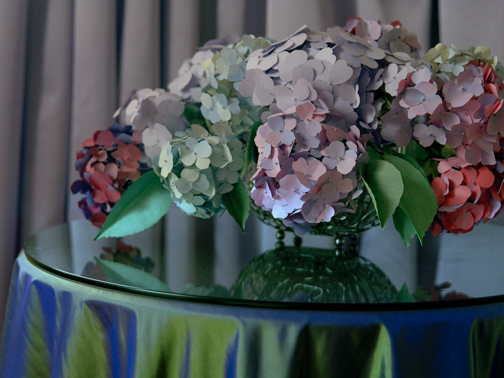 'untitled from the series 310' - giclee print 40x50 inches In making the props for the photographs, I was aware that I had replaced the repetitive action of cleaning with that of making paper flowers, and whilst the props functioned predominantly as a means to construct artifice and effect, I wanted this act of ‘making’ to be visible in the photographs if scrutinised closely, to ensure this I used a 5x4 film camera to document these small sets, which would allow for the production large scale prints. Working with coloured paper to make flowers, I was interested to see how flat colour could be transformed through cutting, bending and shaping and then lighting, into something akin to the origional, and then subsequently return to flat and saturated colour in the surface of photograph. I really like the notion of leaving the greyness as Salman Rushdie writes in his musing on the Wizard of OZ 'In it’s most potent emotional moment, this is unarguably a film about the joys of going away, of leaving the greyness and entering the colour, of making a new life in the ‘place where there isn't any trouble’. Salman Rushdie, BFI Film Classic 1992 ‘The Wizard of OZ’, 
