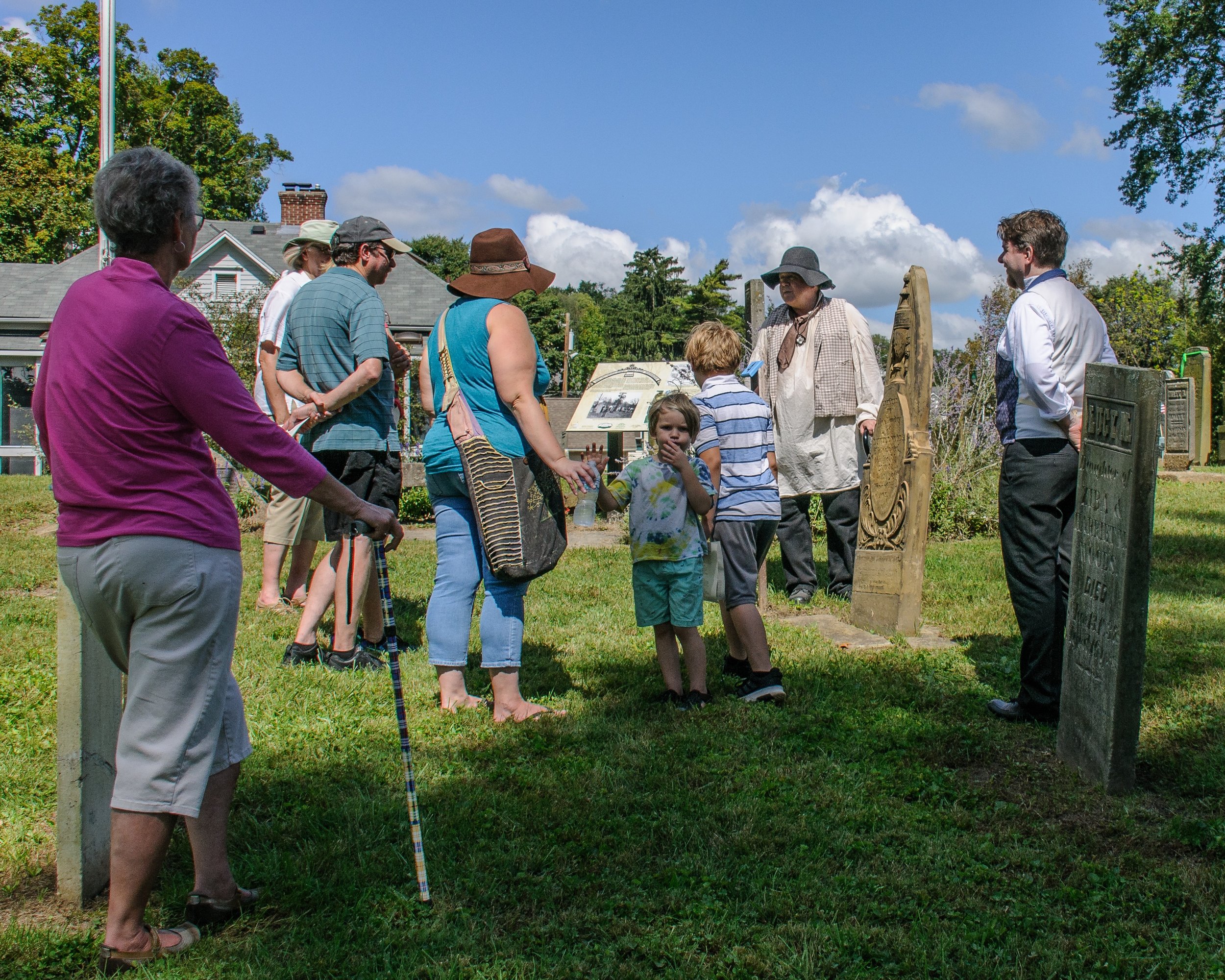 Rev. Thomas Hughes (Brian Gregory) tells visitors about his stone-carving work on Luther Woods' headstone.