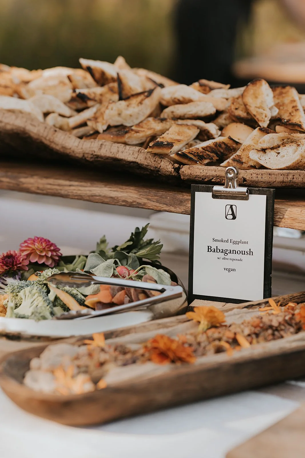 Cocktail hour with Applecroft Catering off-site wedding Sign and flower with appetizers