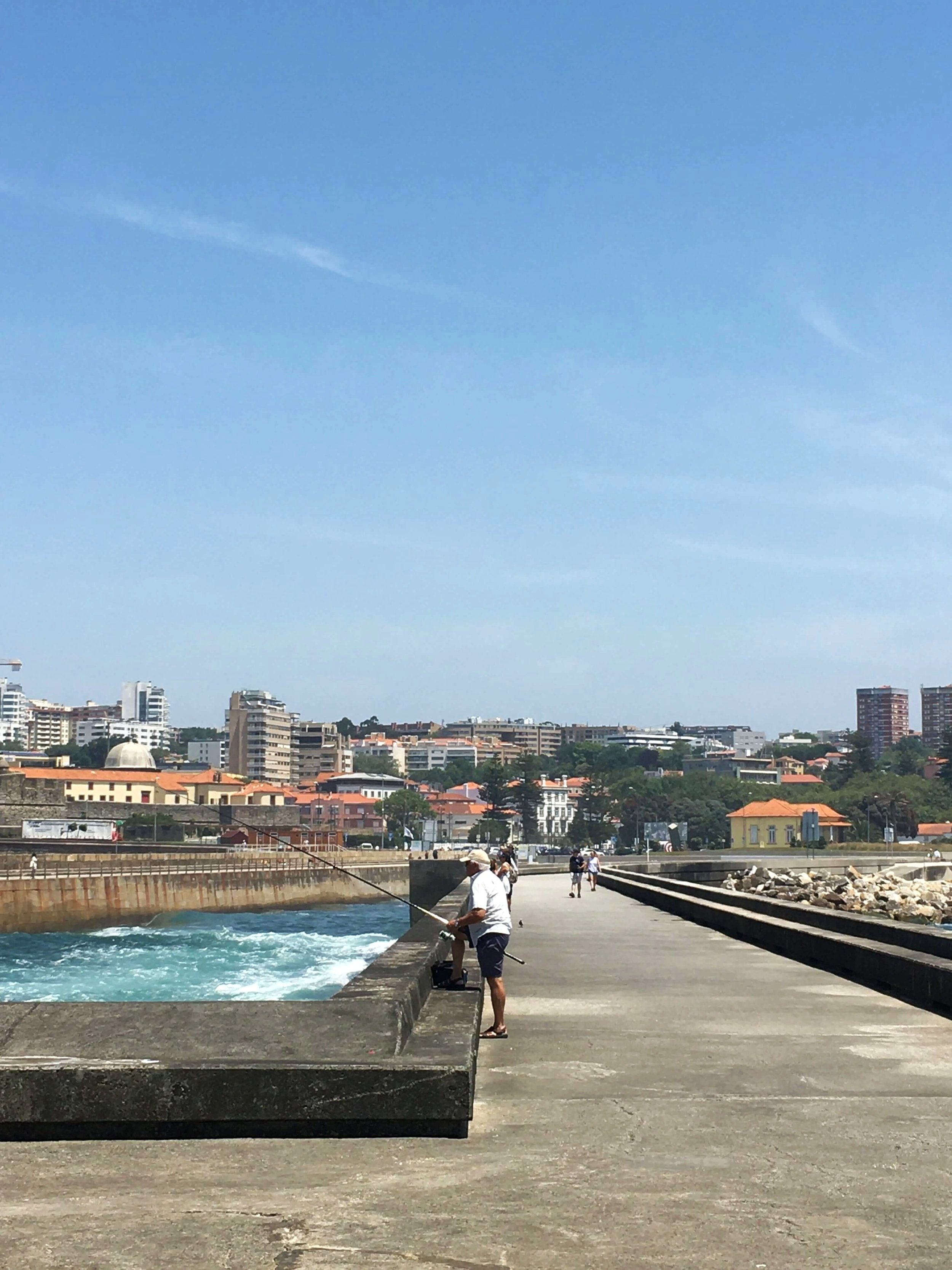 Fisherman casts out from pier at Foz do Douro