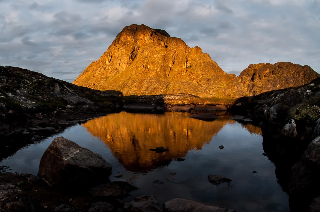 Poslední večerní paprsky osvěcují monumentální horu Nasaasaaq (784 m.n.m.), nedaleko přímořského města Sisimiut, které představuje se svými pět a půl tisíci obyvateli druhé největší grónské město. 