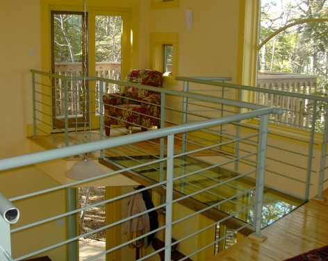 A glass bridge spans to the reading loft and upper deck