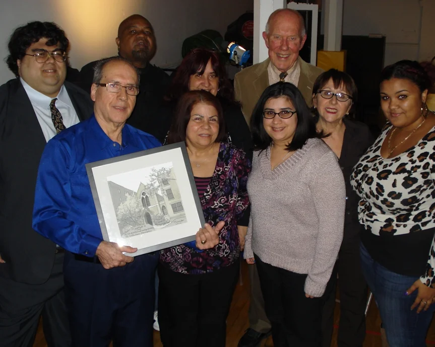 Surrounded by members of his family and Willowtown Association officers, Noel Collado holds his Alfred Award.