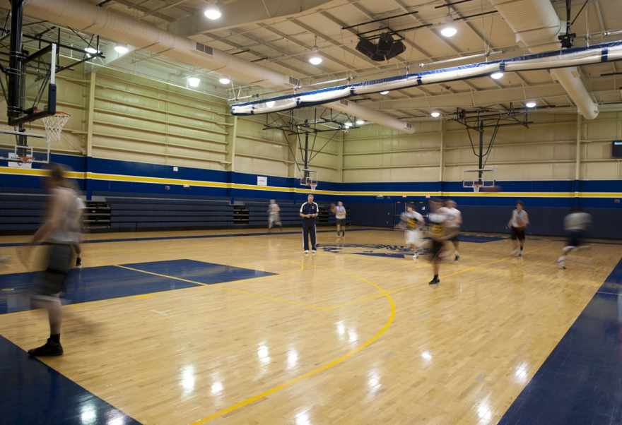 Coach Mike Huff stands in the middle of Trinity's gym reading off the exercises that he wanted his team to do. They were preparing to play a series of teams who they had a history of losing against. Despite that daunting prospect, Coach Huff remained positive and confident. 