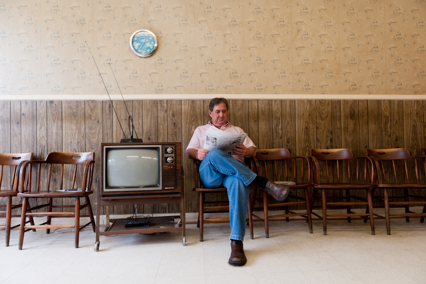 Ritchie Teague, a local barber, reads the Chatham News in his shop. ”I read the paper a lot, because these days work is slow. Everybody likes the fancy glamour shop down the road,” he said.