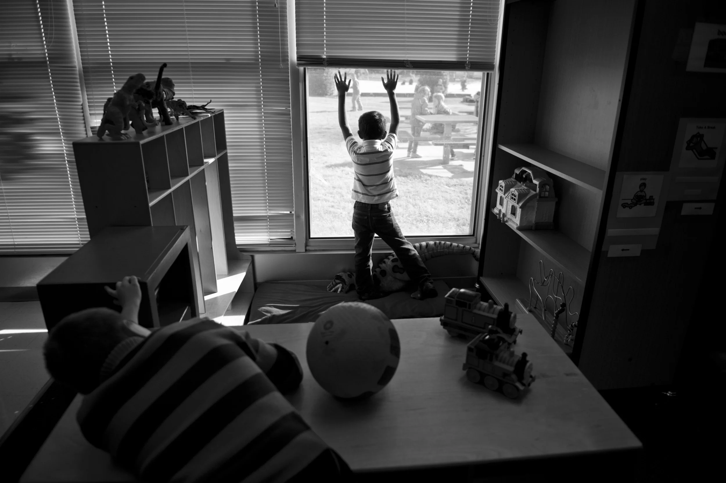 Marcus and a classmate in his autism-specific classroom long to be outside playing with the others.