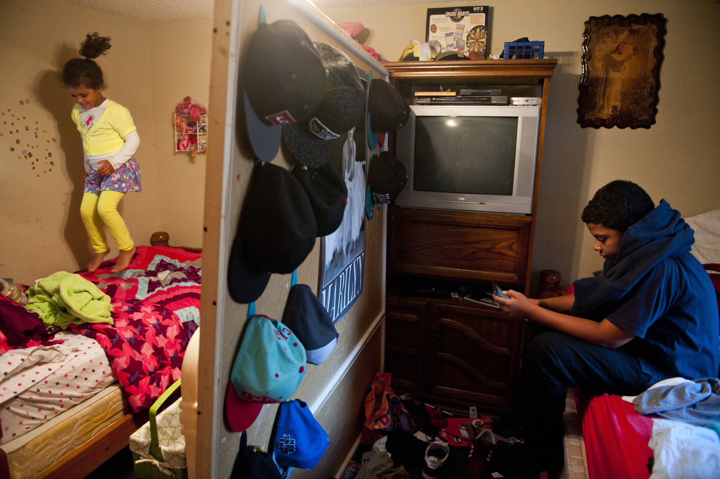  Nevaeh jumps on her bed as Kyle, a reclusive 14-year-old, texts his girlfriend in their Tampa, Fla. home.&nbsp; Kyle and Nevaeh share a bedroom split in half by a large cork board.&nbsp; Kyle complains about not having privacy or quiet.&nbsp; Mary c