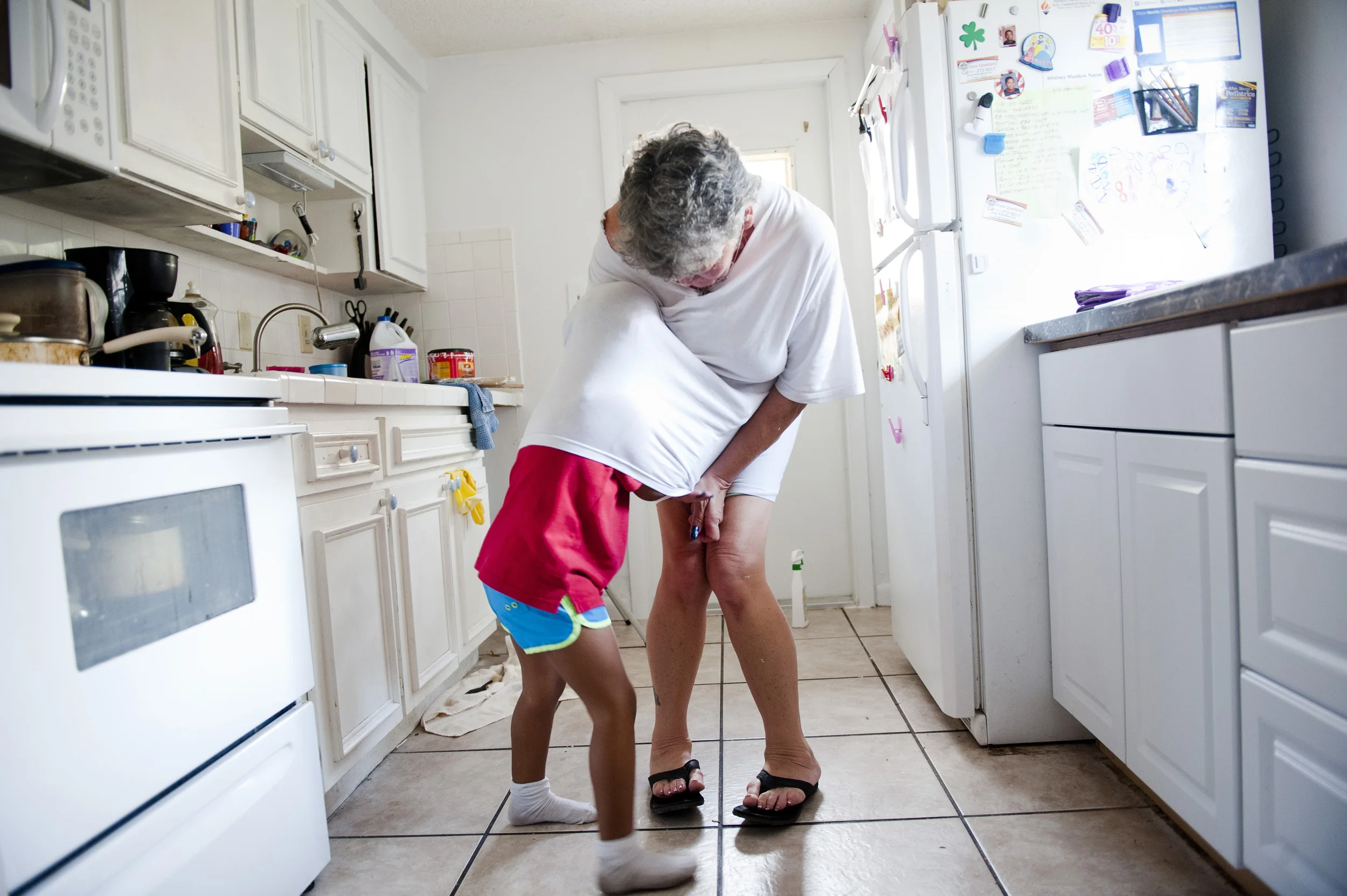  Nevaeh tries to tickle Mary by climbing underneath her shirt in Mary's kitchen.&nbsp; Despite the years of personal and financial struggle that raising her two grandchildren has put on her, she said,&nbsp; "My life without Nevaeh and Kyle would be a