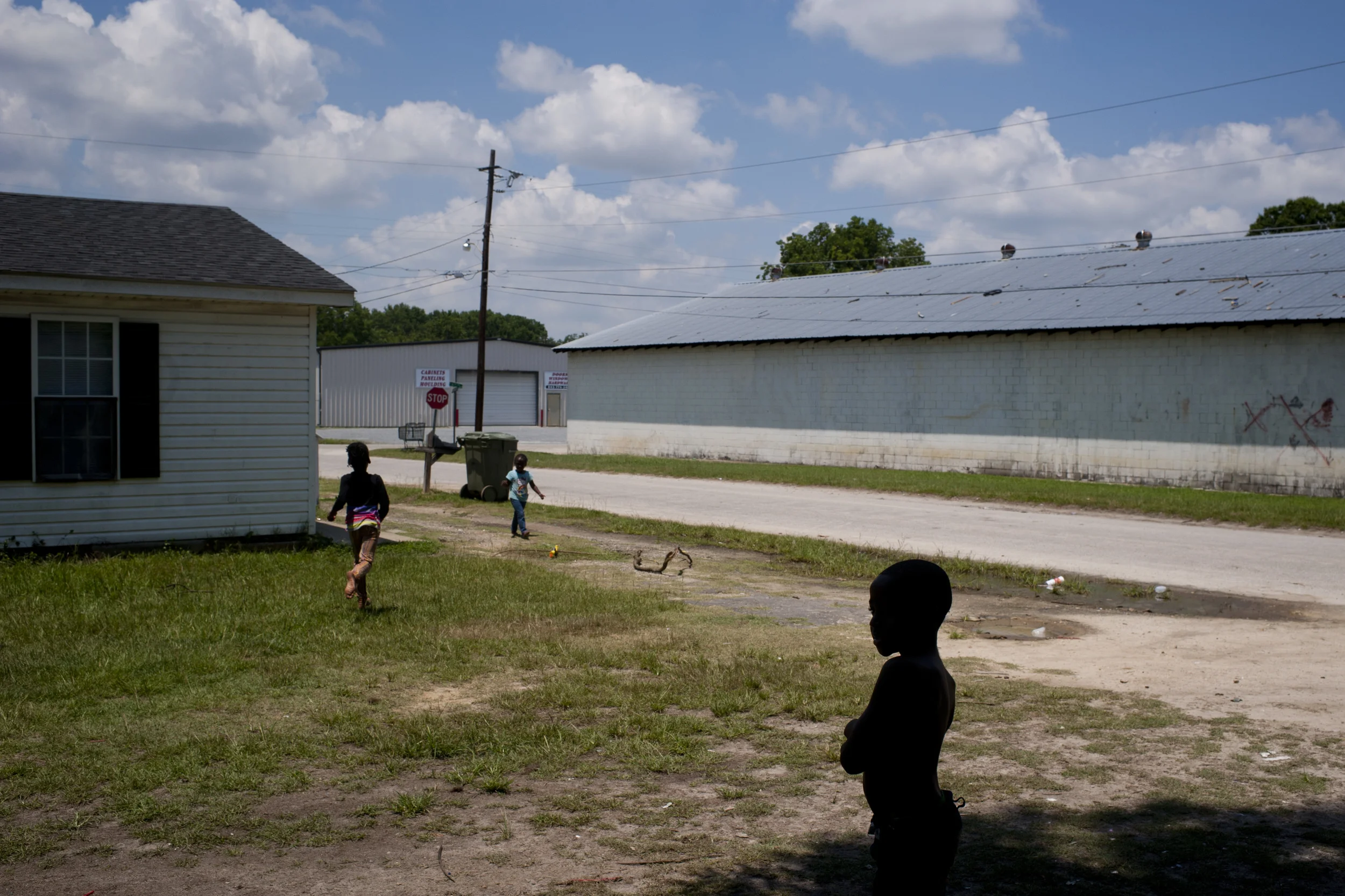  Trying to escape the heat, Qa'Montae Brown, 7, stands in the shade of a tree near his home in Dillon, S.C. on Saturday July 12, 2014. &nbsp;Dillon sits at the north end of the Corridor with an 88 percent minority population. &nbsp;Many residents of 