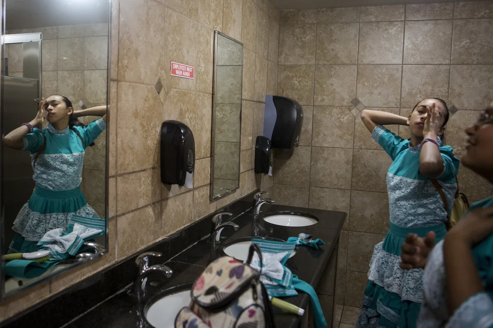 Jackie Ayala and Kristy Escamilla do their hair in the bathroom of a gas station along I-35 on February 21, 2015. The girls were on their way to represent the team at Junta Estatal para Capitanas, or the State Meeting for Captains, in Temple, Texas. 