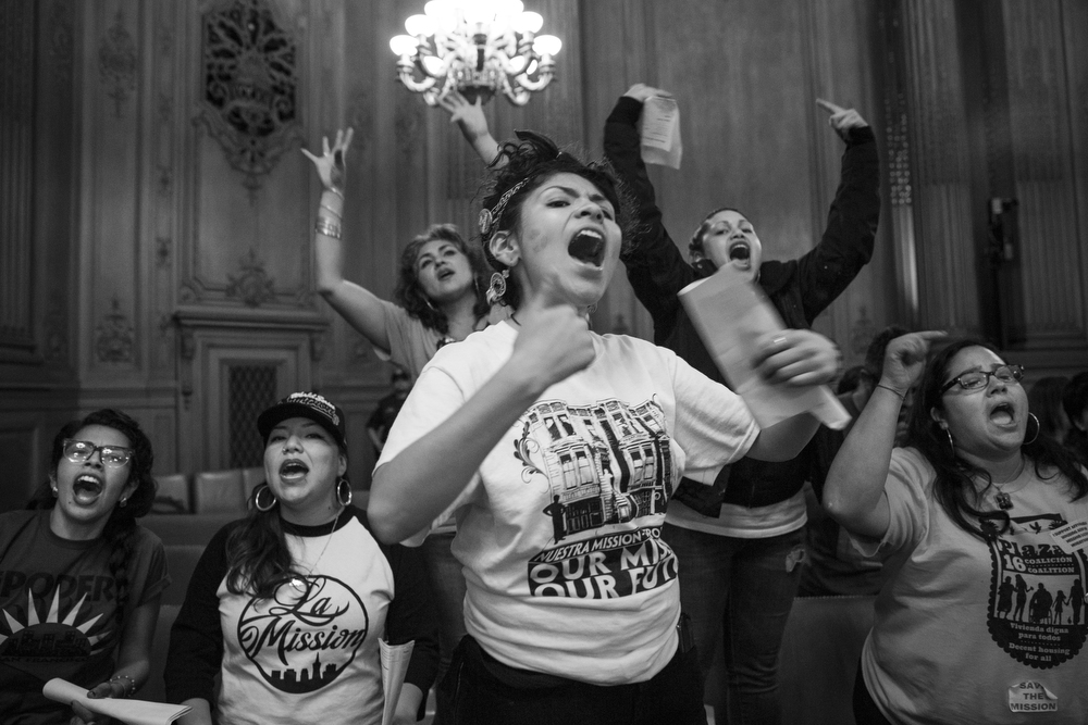 At nearly midnight on June 2, 2015, Alondra Aragon, center, led a chant in City Hall in San Franciso, Calif. immediately after the Mission Moratorium was voted on. The final vote was 7-4 in favor of the moratorium, but the measure needed nine votes to be passed as an "interim emergency ordinance." Aragon and dozens of other Mission Moratorium supporters had filled the room for over eight hours that day. Of the supporters, San Francisco Board of Supervisors Member John Avalos said, "The rich fabric of the Mission is what is here today." Katy Tang, the supervisor from District 4, said, "This was incredibly moving for me, although at times emotional, very inspirational." 