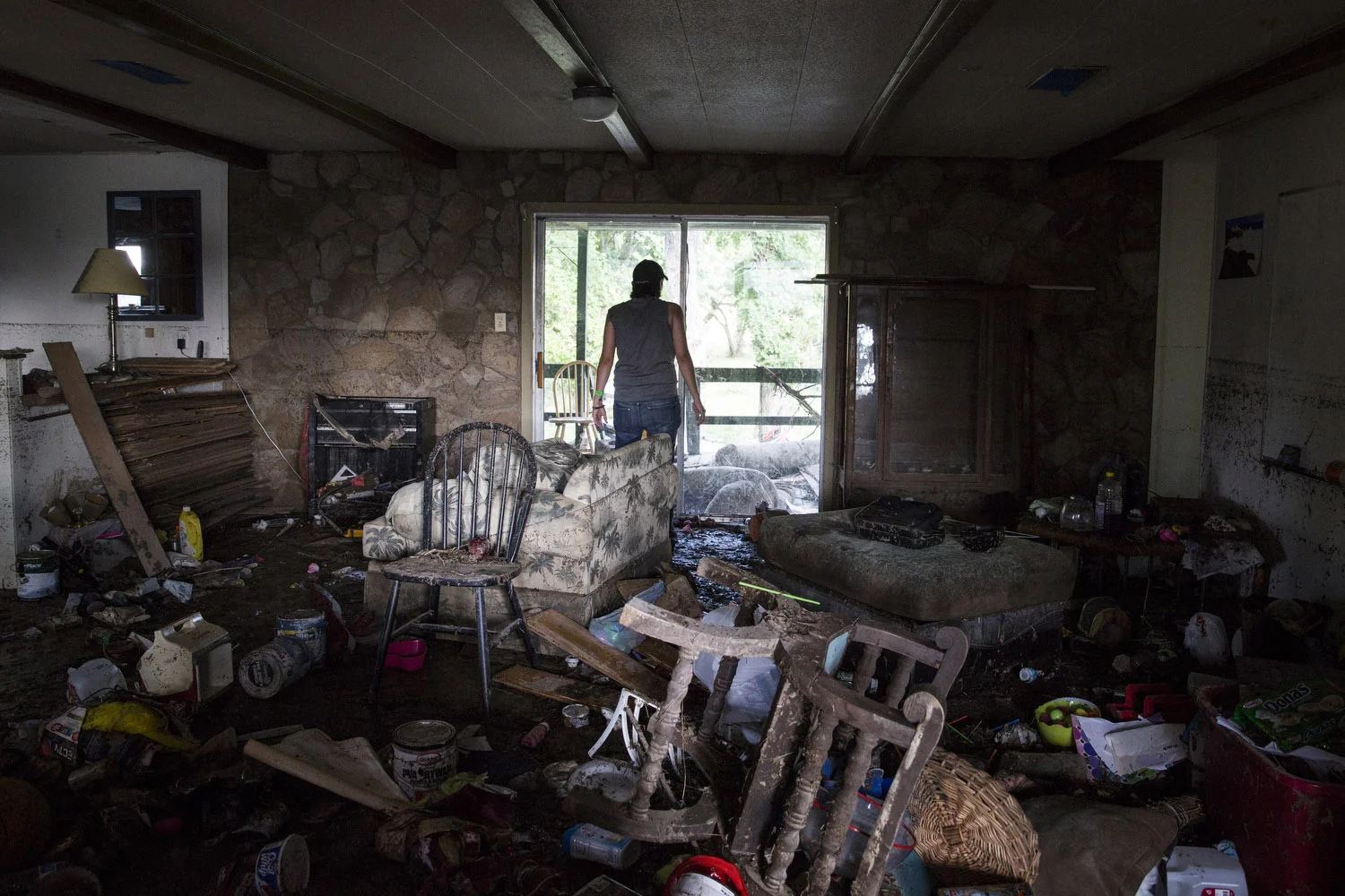 Glenda Bamberger looks out of the back door of her home in Blanco, Texas on Friday, May 29, 2015. Bamberger, who was born and raised in Blanco, said, "We put everything into buying this house and now I am not sure we will want to rebuild." The line on the wall to Glenda's left shows how high the water rose. 