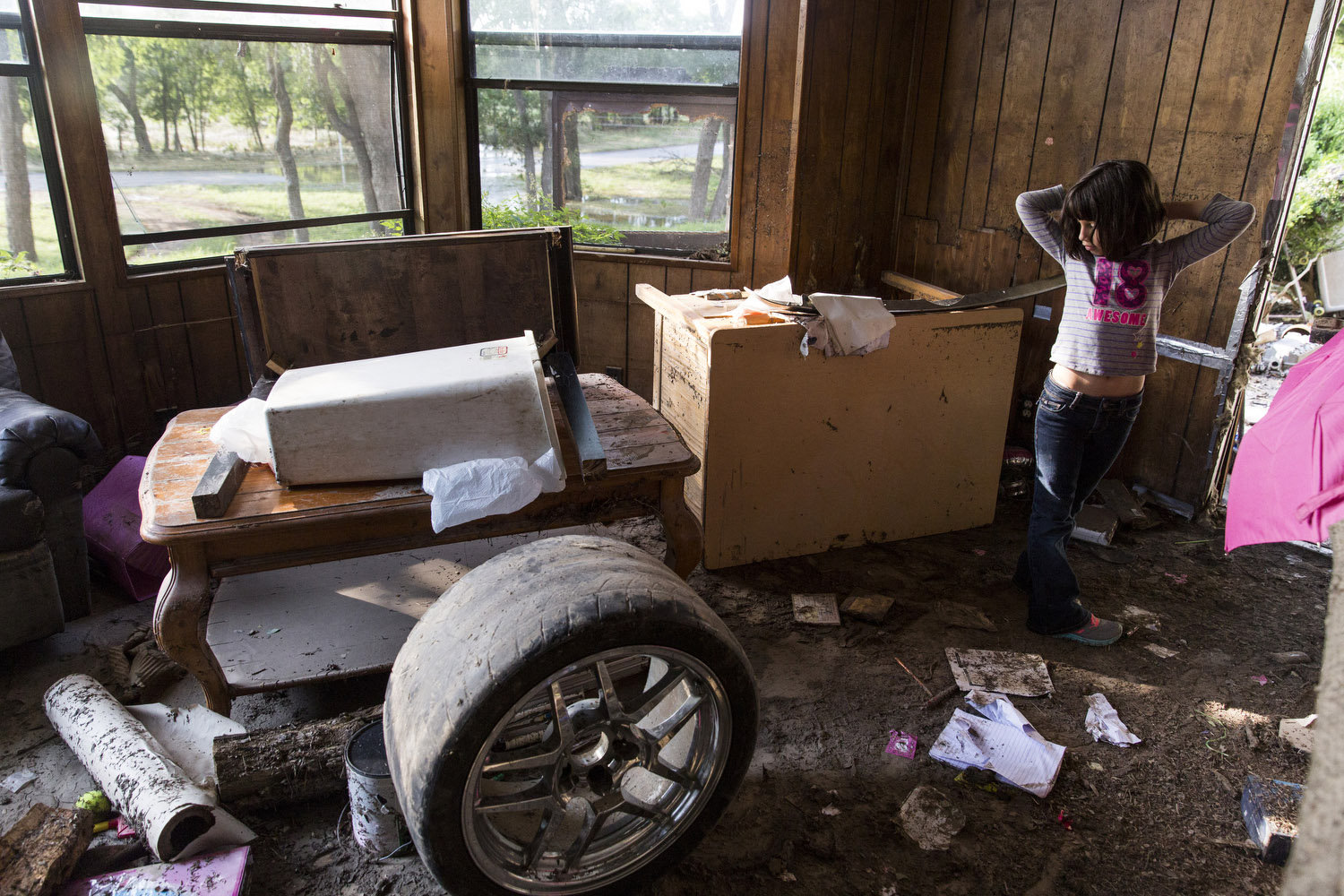 Serenity Bamberger, 7, looks at the damage in her home in Blanco, Texas on Friday, May 29, 2015. Of the donations that have flooded in to help Serenity and her family, she said, "It is like Christmas." However, her mother Glenda Bamberger said that Serenity and her sister Cielo were very upset at first.