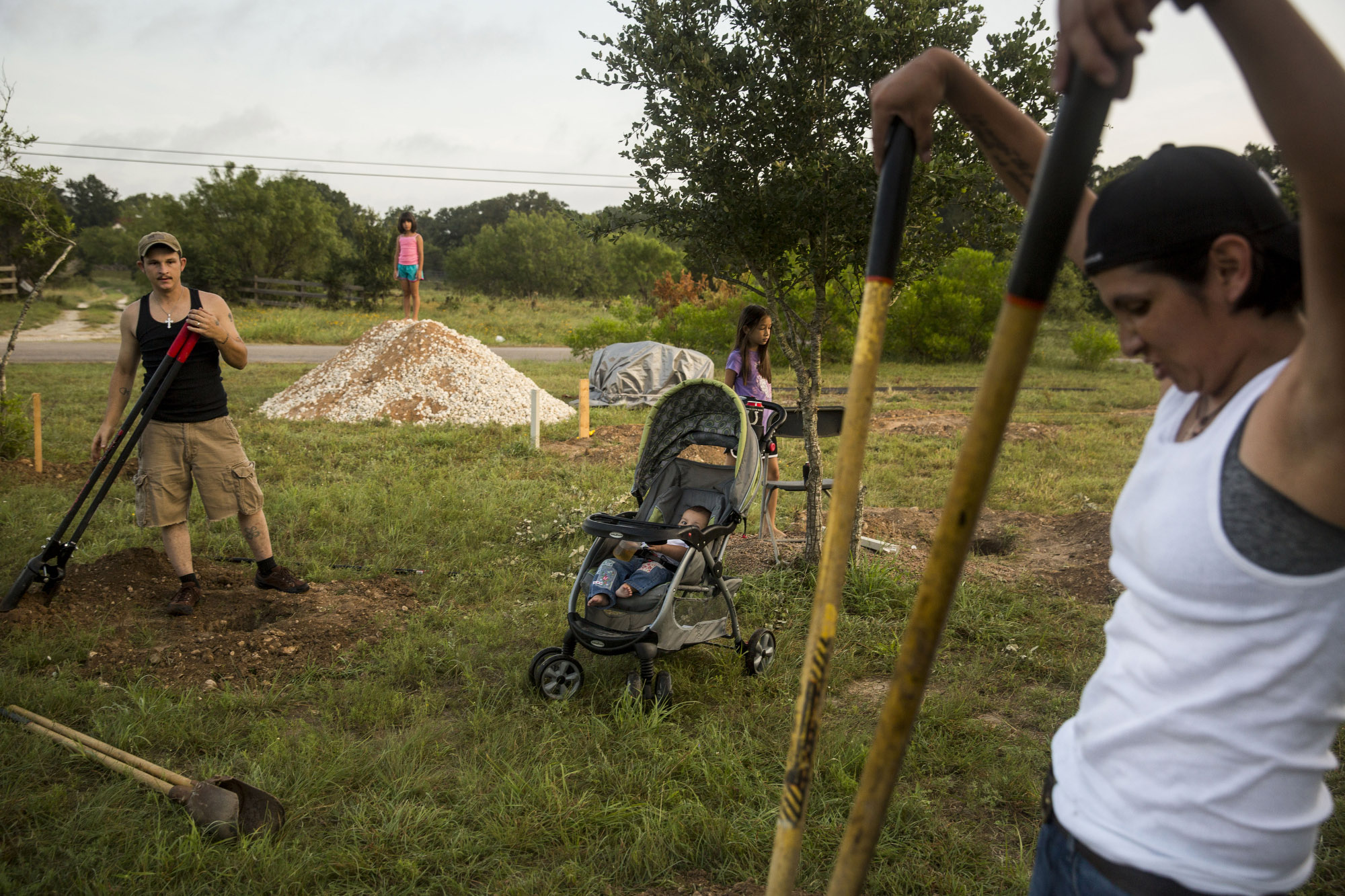 Glenda Bamberger, right, and her husband Jarrell Bamberger, left, widen holes dug in their yard in Blanco, Texas on July 11, 2015. Their home was destroyed in the floods that occurred in May along the Blanco River in Central Texas. They poured a concrete pillar in each of the twelve holes for the house they are building to replace the one that flooded. The house will be eight feet off the ground in the hope that it will not be affected by future floods on their property. 