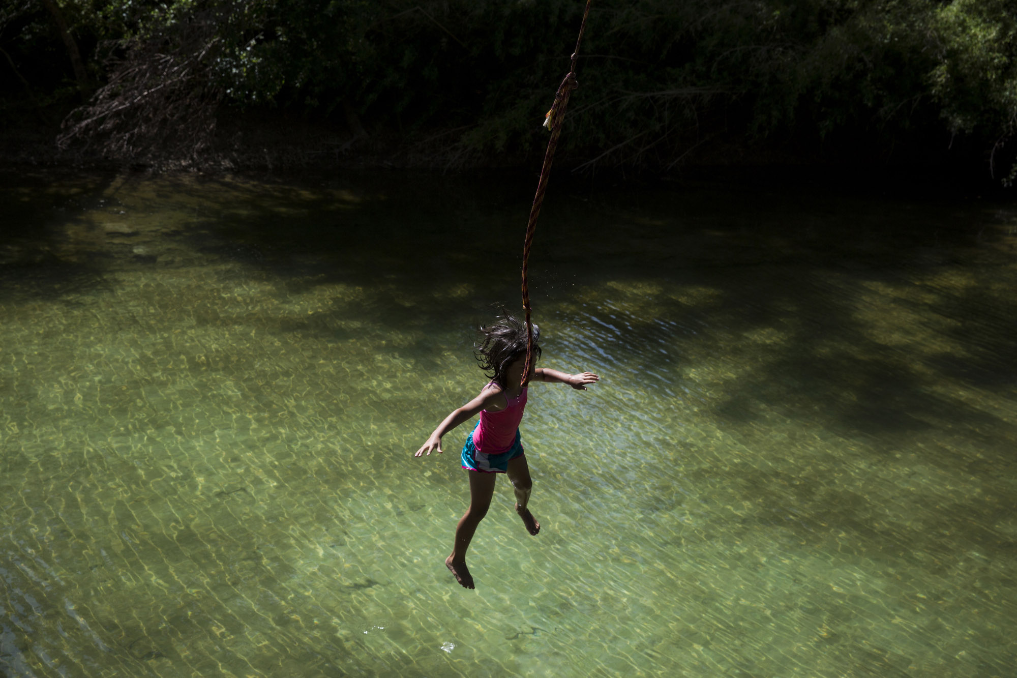 Serenity Bamberger, 7, falls from a rope swing behind her house into the Little Blanco River on July 11, 2015 in Blanco, Texas. Two months prior, the same river flooded their home destroying the majority of the family's belongings. Despite the toll the river has taken, Bertha Rivera, Bamberger's grandmother, said, "The river bed was dry for years, so now that the water is here I tell the girls to take advantage of it all that they can."