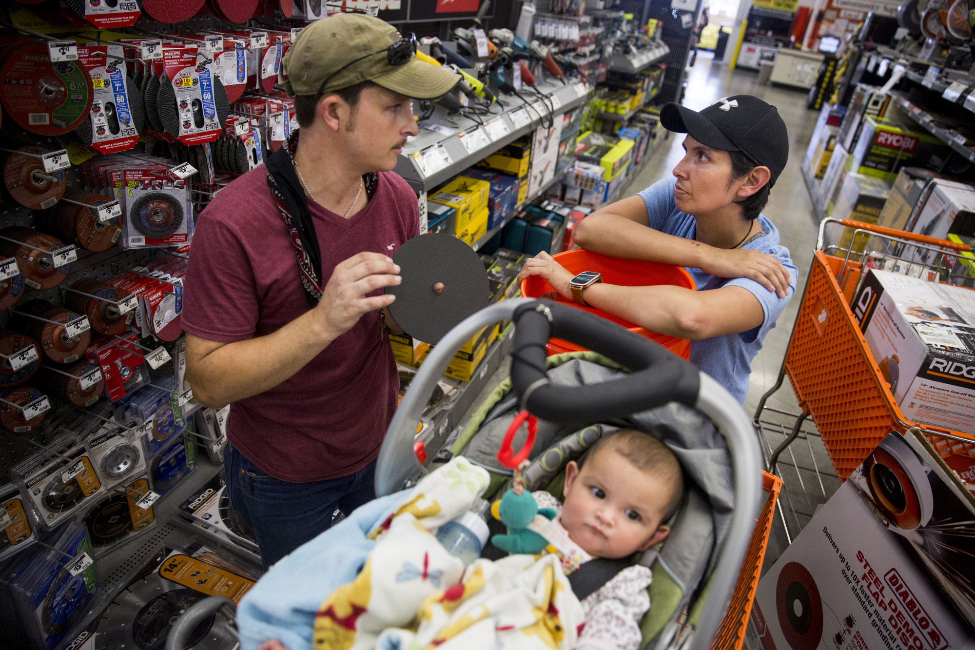 Jarrell Bamberger talks to his wife Glenda Bamberger about what they need to start building their home while their daughter Esmebella, 9 months, sits in their shopping cart at Home Depot in Bulverde, Texas on July 10, 2015. They began construction on their new home the next day. 
