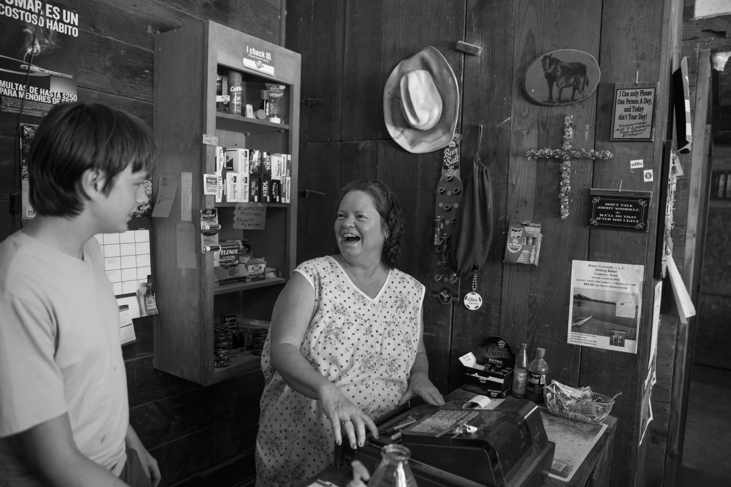 Joy Tipton and her son Evan Tipton laugh as they joke about how much Evan works at the Tipton family's roadside store The Little White House in Fowlerton, Texas on August 5, 2015. The store is along the highway between Tipton, Texas and Cotulla, Texas, and mainly serves hunters and oil field workers. Joy Tipton said that she hears fewer oil field trucks driving by everyday and that business is dwindling.